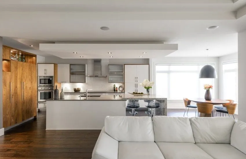 Зонирование пространства кухни-гостиной с помощью многоуровневого потолка